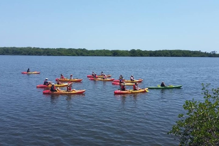 a group of people rowing a boat in a body of water