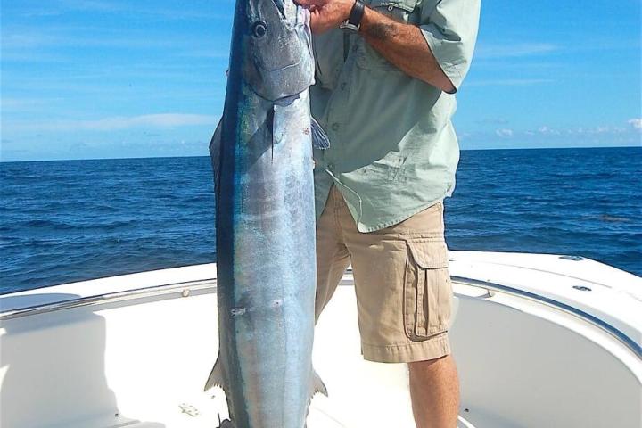 a man holding a fish in the water