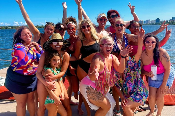 a group of people on a beach posing for the camera