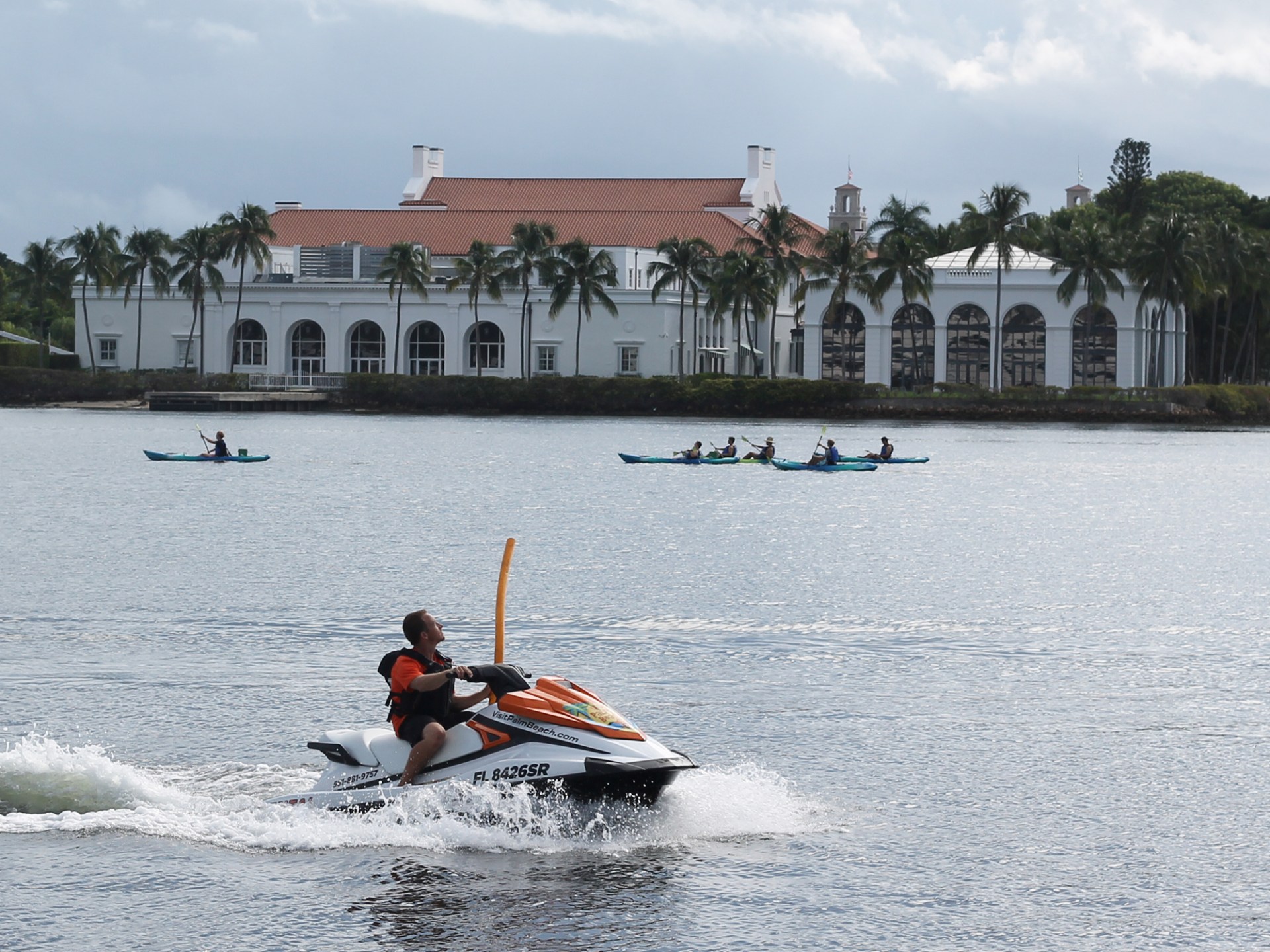a group of men riding on the back of a boat in the water