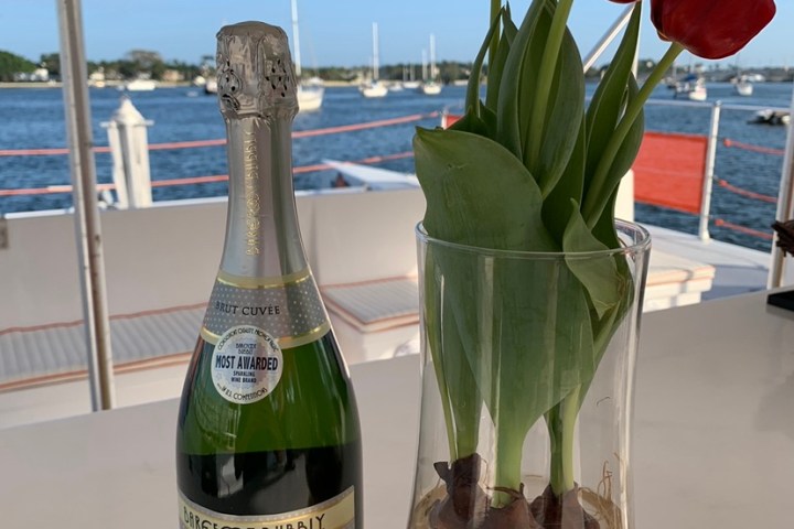 a bottle of wine and a vase of flowers on a table