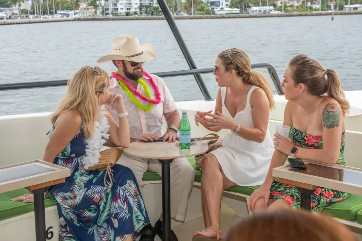 a group of people sitting on a bench next to a body of water