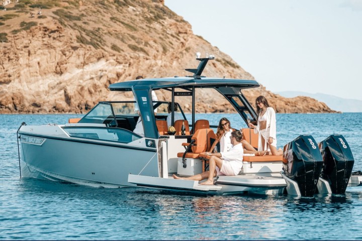 a group of people riding on the back of a boat in the water