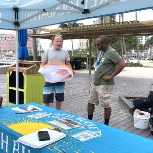 a group of people sitting at a table with a cake