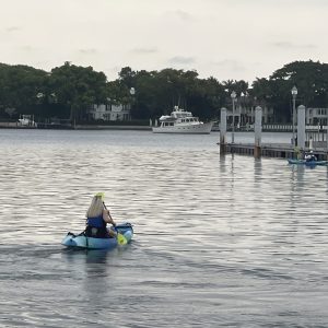 a group of people riding on the back of a boat in the water