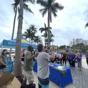 a group of people standing next to a palm tree