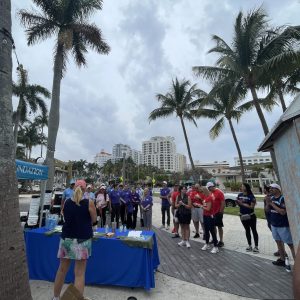 a group of people standing next to a palm tree