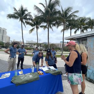 a group of people standing next to a palm tree