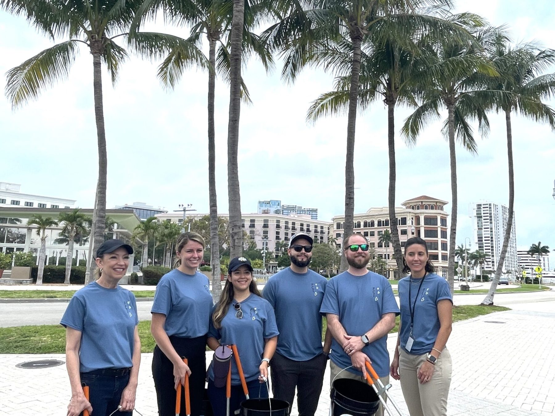 a group of people standing next to a palm tree