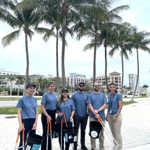 a group of people standing next to a palm tree