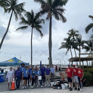a group of people standing next to a palm tree