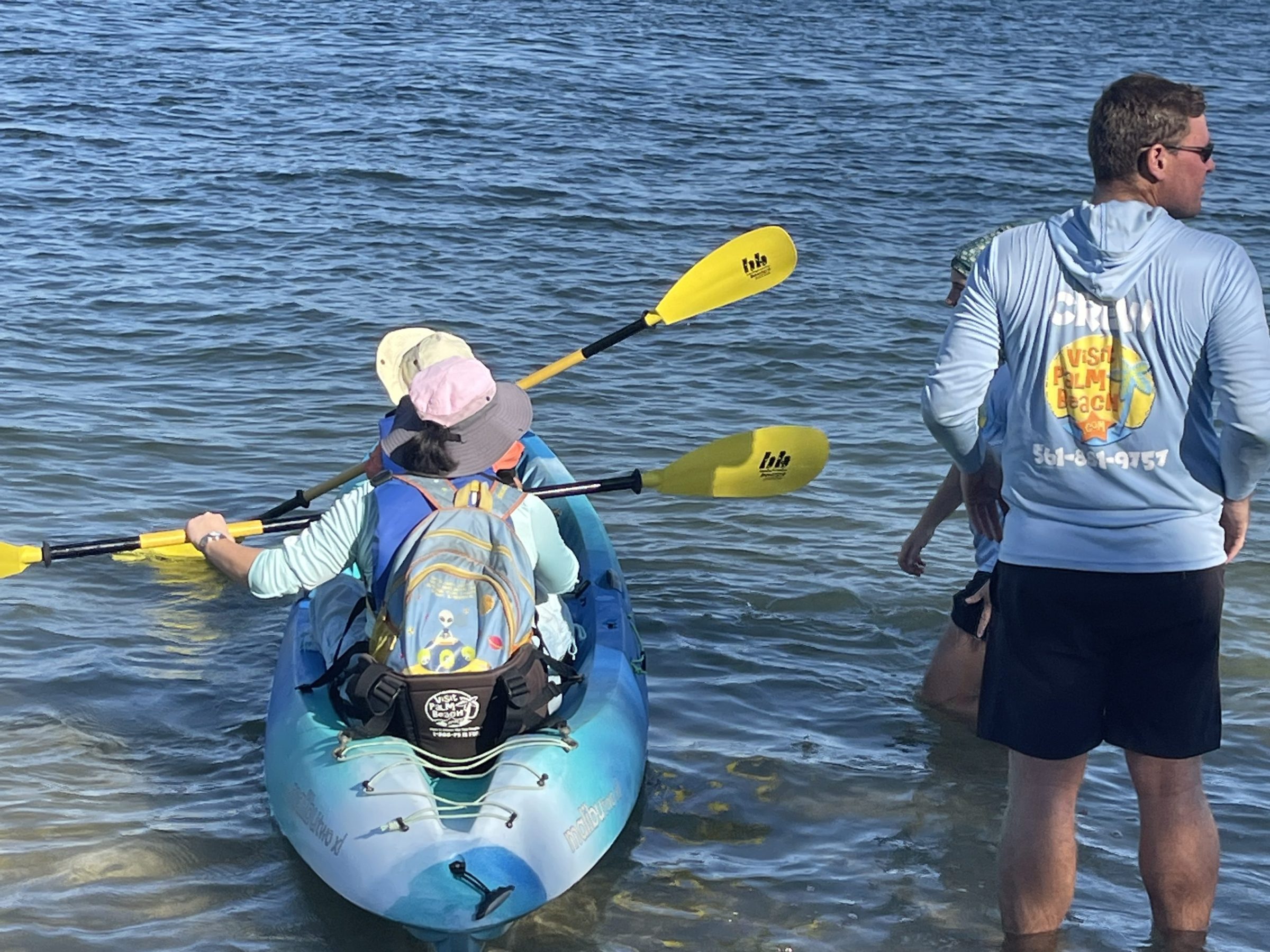 a group of people standing next to a body of water