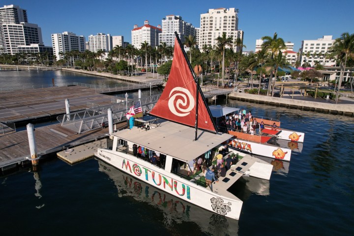 a small boat in a body of water with a city in the background