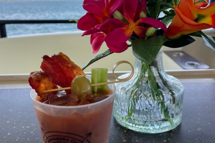 a vase of flowers on a table next to a cup of water