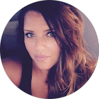 Woman with long brown hair and a black tank top, looking at the camera.