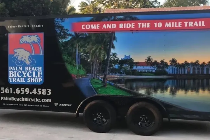 Trailer with Palm Beach Bicycle Trail Shop ad and scenic photo.